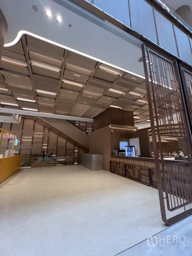 Retail Space for rent - Modern mall retail area with wood‑panel ceiling, high clearance and escalator access