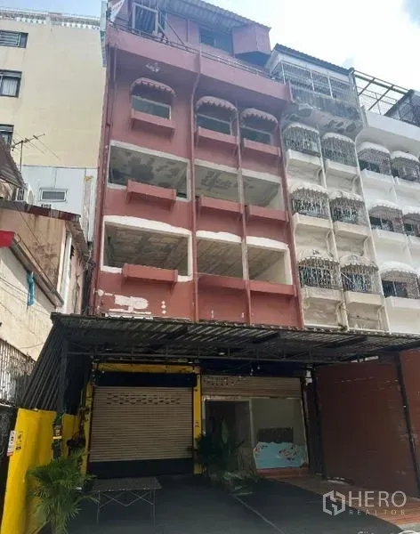Shophouse for rent in Khlong Toei, Bangkok - Multi-storey shophouse exterior on a Sukhumvit side street with open balconies, ground-floor roller shutters, and a covered forecourt near BTS Nana in Bangkok.