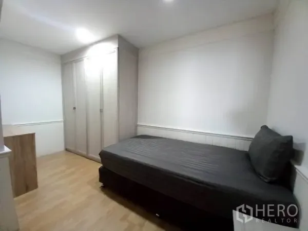 Condominium for rent in Khlong Toei, Bangkok - Cozy second bedroom with a single bed, built-in wardrobe, and a small desk.