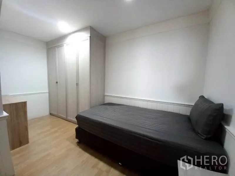 Condominium for rent in Khlong Toei, Bangkok - Cozy second bedroom with a single bed, built-in wardrobe, and a small desk.