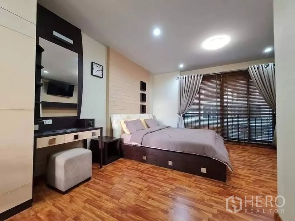 Townhouse for rent in Khlong Toei, Bangkok - Another angle of the master bedroom showing a vanity, mirror and floor-to-ceiling windows.