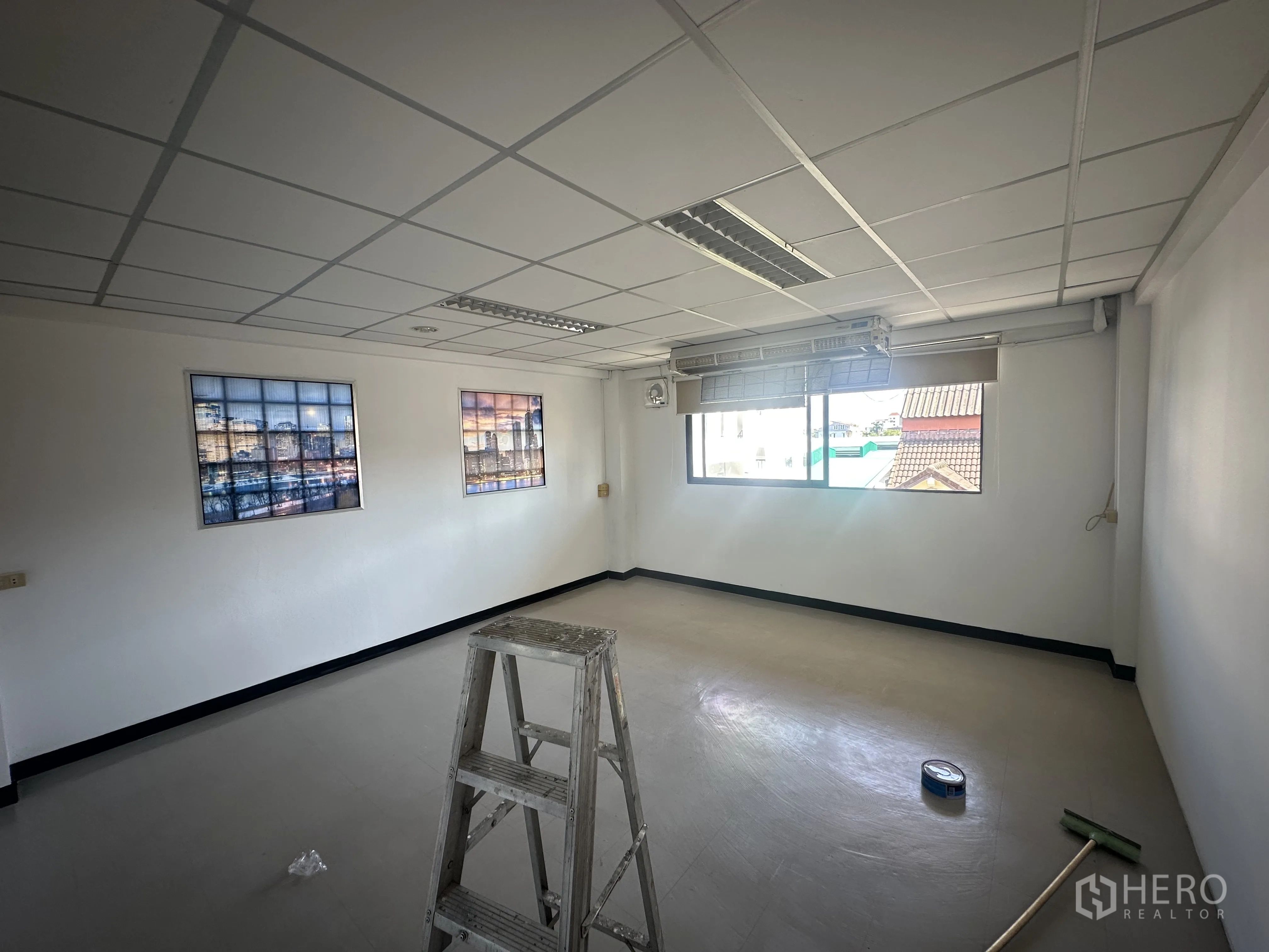 ออฟฟิศ for rent in Watthana, Bangkok - ห้องสำนักงานรองพร้อมหน้าต่างและมู่ลี่ มีภาพติดผนัง บันได และอุปกรณ์ทำความสะอาดบนพื้น