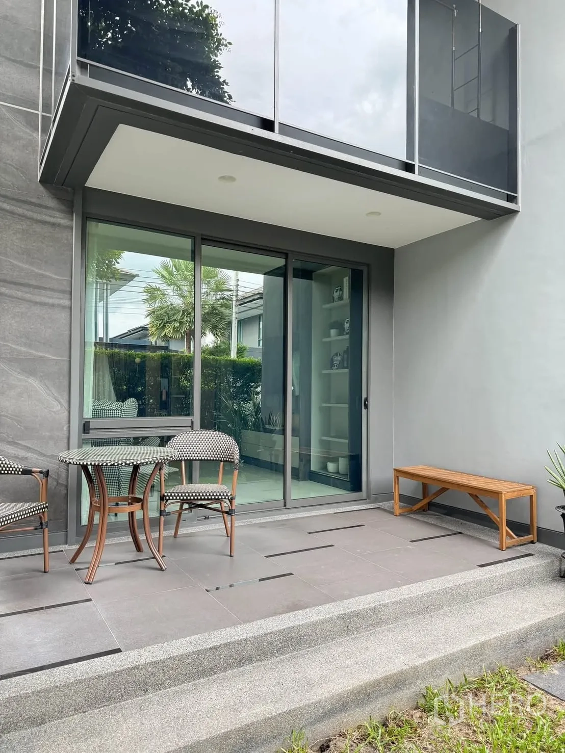 Detached House for rent in Bang Kapi, Bangkok - Private patio with sliding doors, small table and chairs, and garden edge.