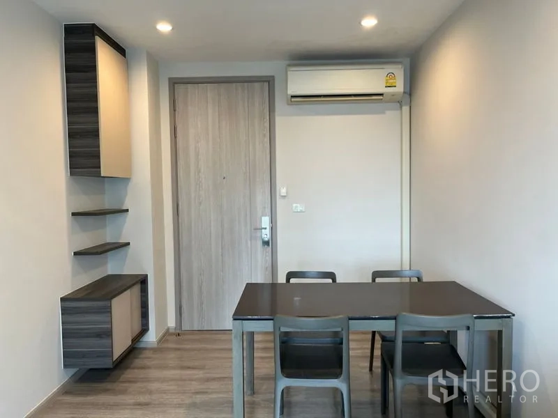 Condominium for sale in Phaya Thai, Bangkok - Dining area with four-seat table, built-in shelves and air-conditioning by the entry.