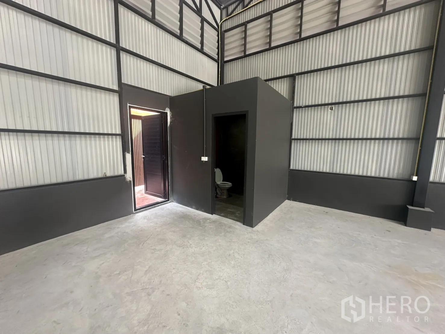 Warehouse for rent in Prawet, Bangkok - Internal block housing a restroom and access door inside the warehouse space.