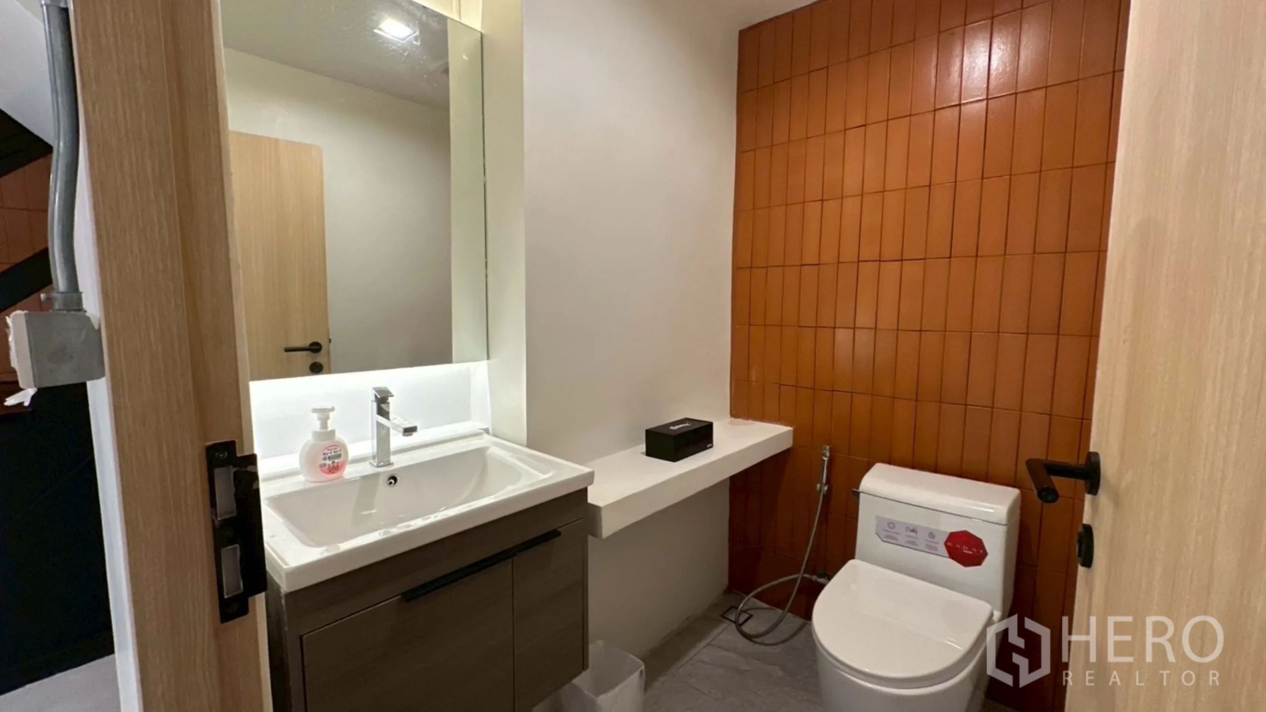 Home Office for rent in Watthana, Bangkok - Compact bathroom with orange accent tiles and white sanitary ware.