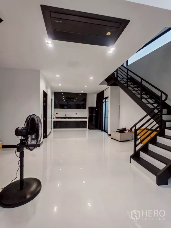 Detached House for rent in Wang Thonglang, Bangkok - Open-plan ground floor showing staircase, recessed lighting, and kitchen.