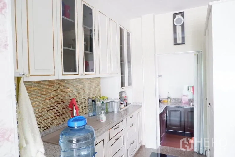 Detached House for sale in Saphan Sung, Bangkok - Light kitchen with white cabinetry, mosaic backsplash and a secondary prep area.