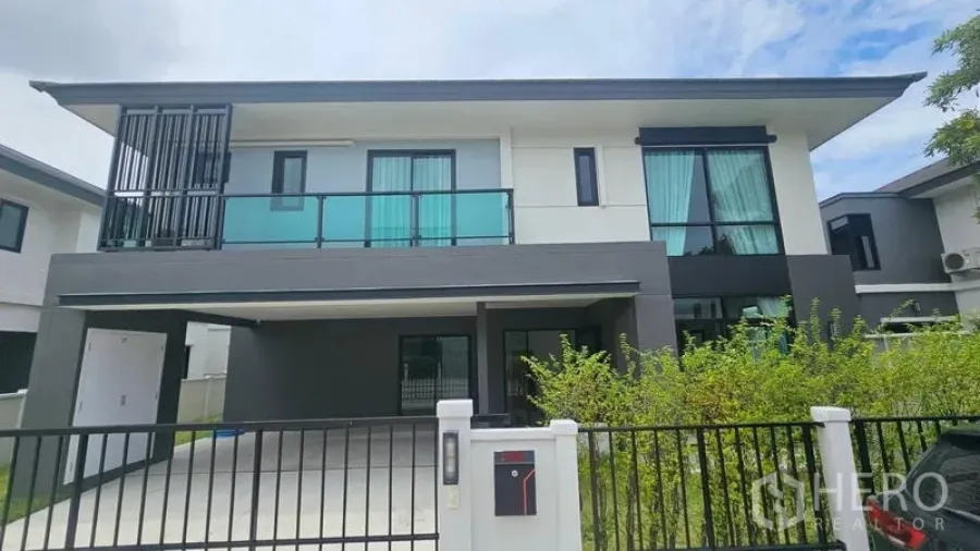 Detached House for rent in Bang Bo, Samut Prakan - Front elevation of the detached house with balcony and glass railing.