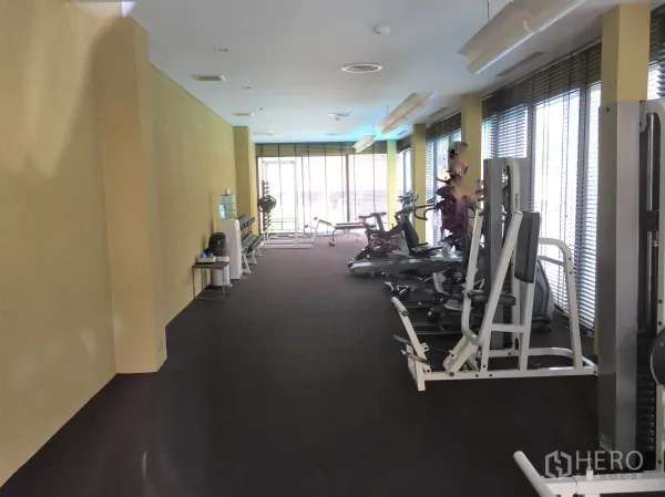 Townhouse for sale in Suan Luang, Bangkok - Residents’ gym with weight machines, cardio equipment, and full-height windows.