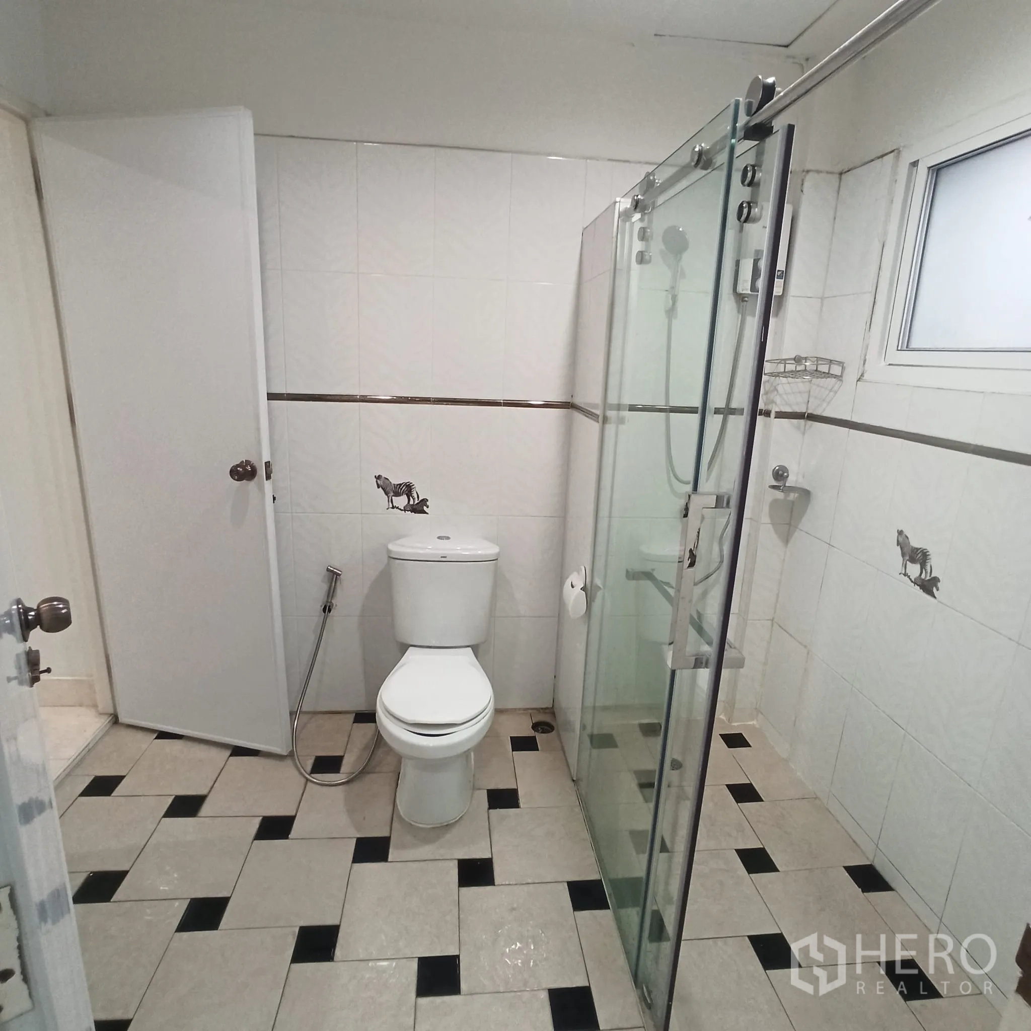 Townhouse for rent in Wang Thonglang, Bangkok - Bathroom with glass-enclosed shower and tiled floor.