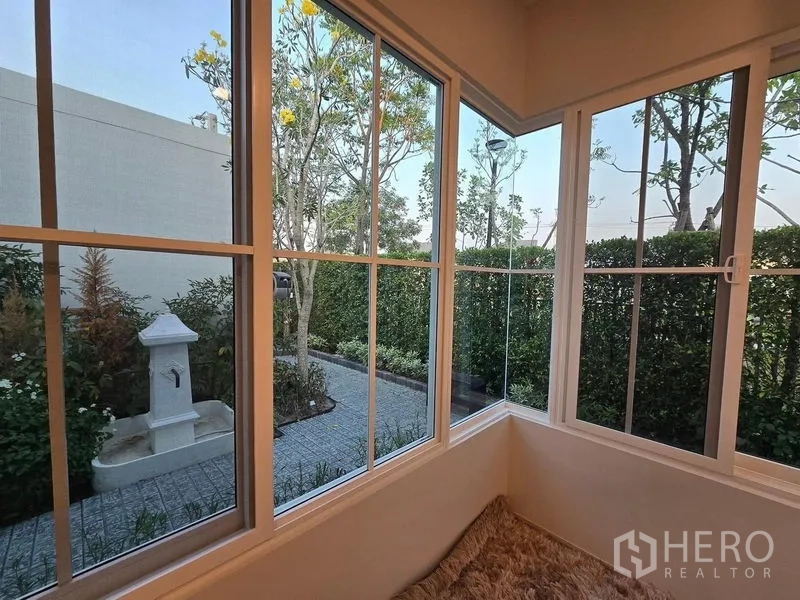 Detached House for rent in Bang Phli, Samut Prakan - Garden view from a bay window showing paved path, hedges and a small decorative fountain.