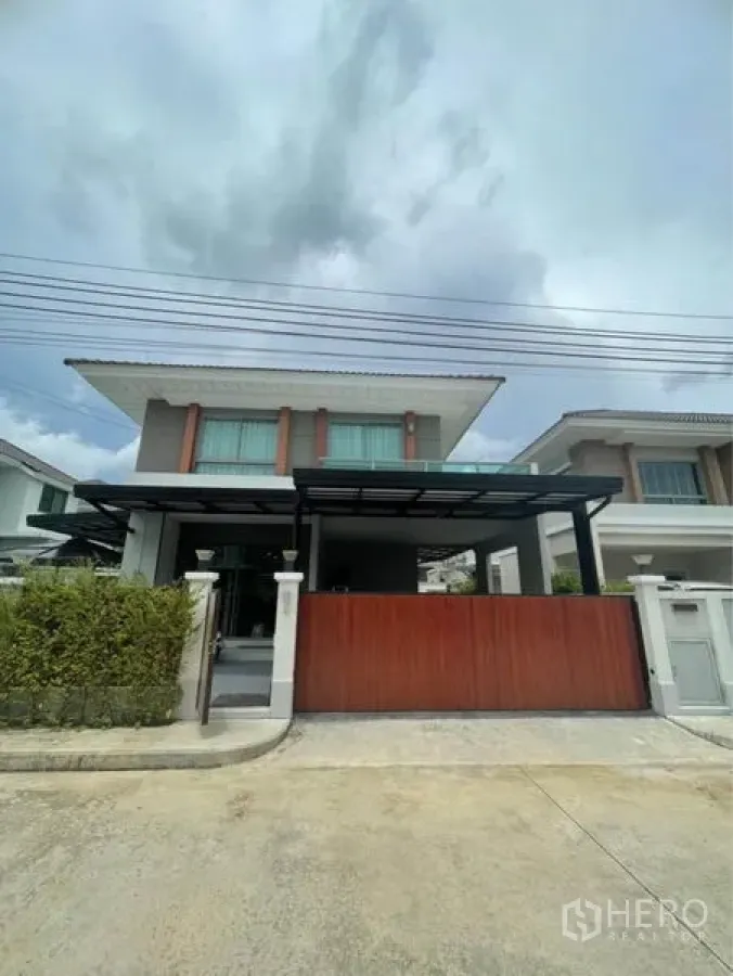 独立式住宅 出售在Lat Krabang, Bangkok - 现代两层立面，推拉大门与带顶车棚。