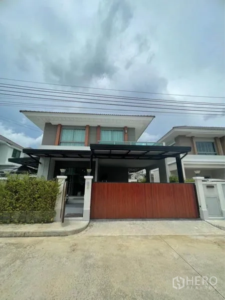 独立式住宅 出售在Lat Krabang, Bangkok - 现代两层立面，推拉大门与带顶车棚。