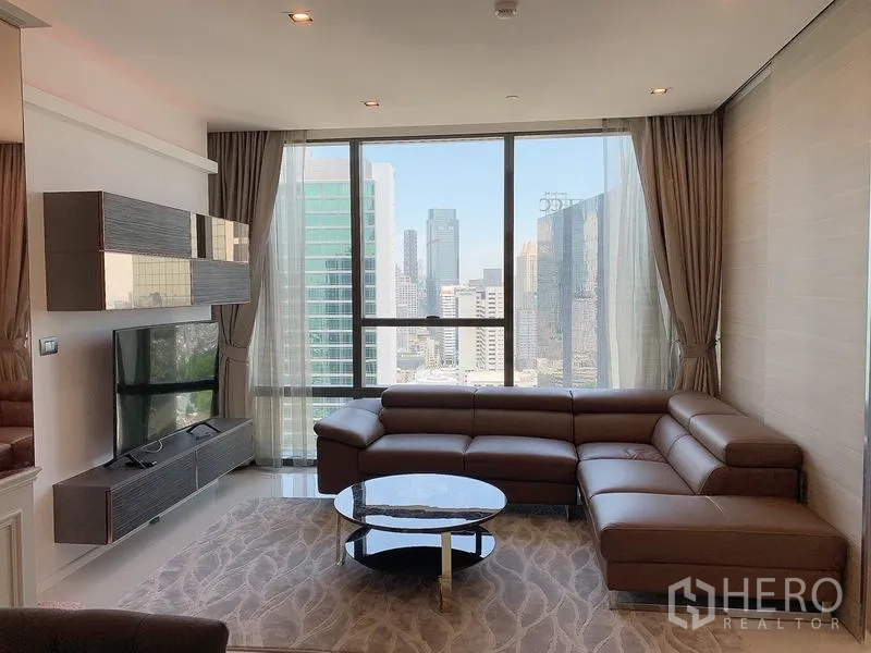 Condominium for sale - Living area with L-shaped leather sofa and wide city views.