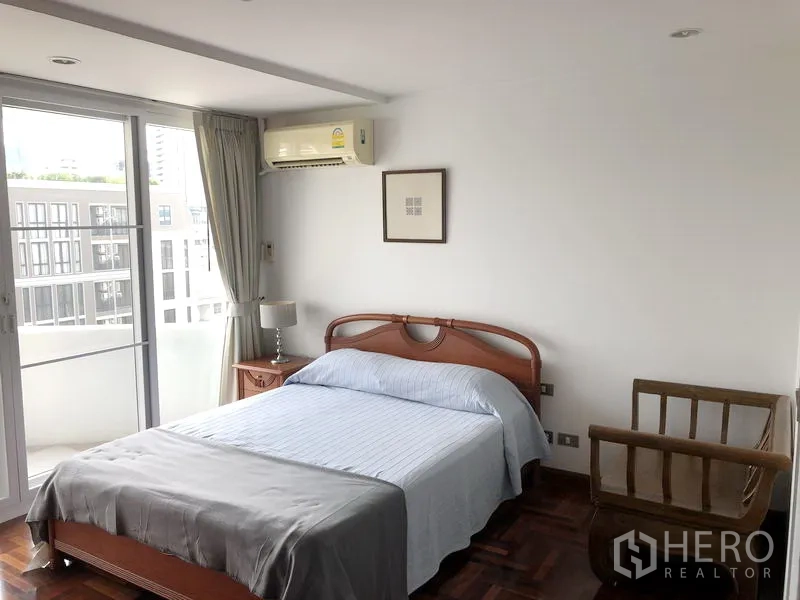 Condominium for rent or sale in Watthana, Bangkok - Second bedroom with double bed, bedside table and sliding door to balcony.