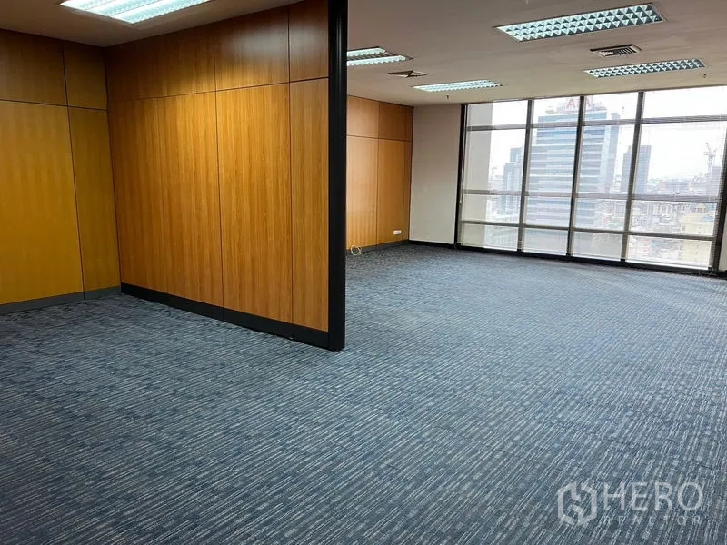 Office Space for rent - Open-plan workspace with floor-to-ceiling windows offering city views beside wood partitions.