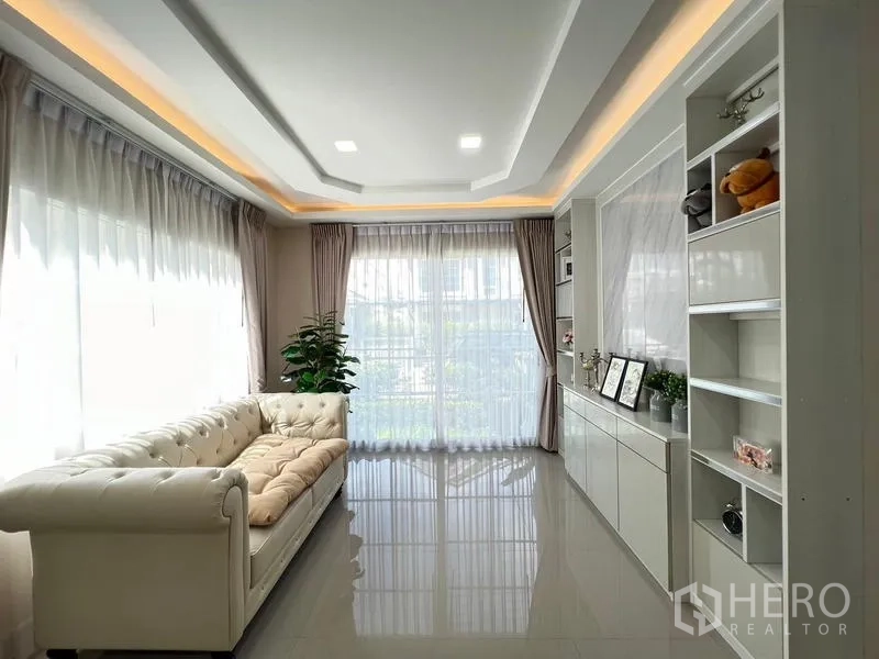 บ้าน ให้เช่าหรือขาย - อีกมุมของห้องนั่งเล่นพร้อมหน้าต่างบานใหญ่และไฟฝ้า