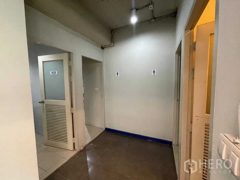 สำนักงาน ให้เช่าในRatchathewi, Bangkok - โถงทางเดินที่มีประตูห้องน้ำชายและหญิงภายในชั้นสำนักงาน