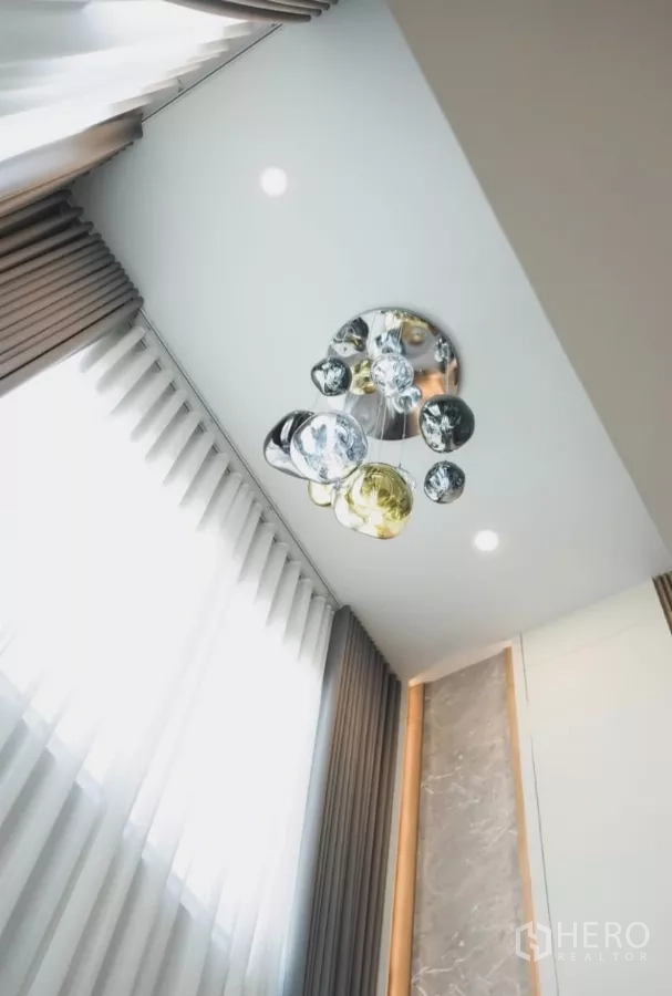 Detached House for rent in Bang Phli, Samut Prakan - Statement multi-globe chandelier hanging from high ceiling beside tall curtains.