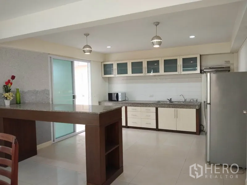 独立式住宅 出租在Watthana, Bangkok - 开放式厨房带中岛与吊灯，配不锈钢冰箱