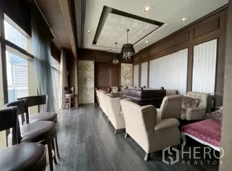 Retail Space for rent - Bright lounge space with bar stools, rows of armchairs, and full-height windows along one side.