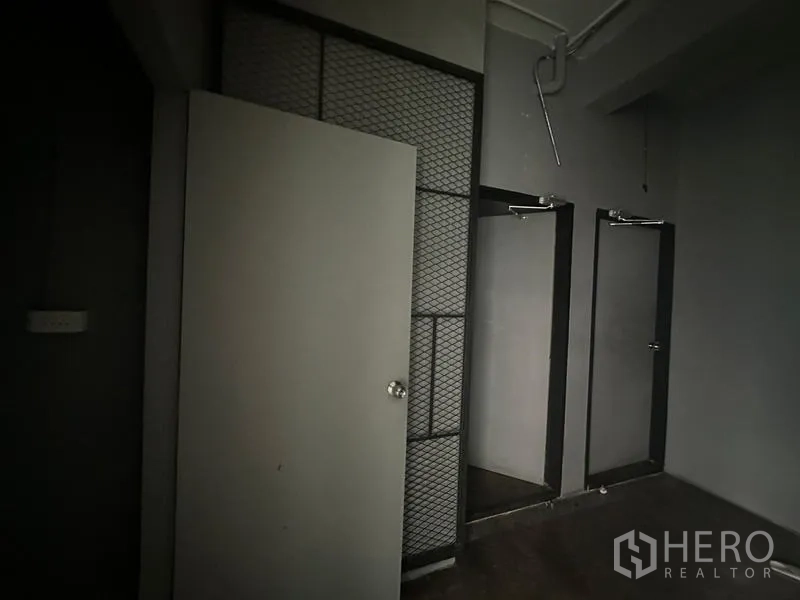 Retail Space for rent - Back-of-house area with two partitioned rooms and metal mesh accents suitable for storage or fitting rooms.