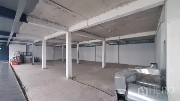 办公空间 出租在Phaya Thai, Bangkok - 办公室角部视角，层高开阔，结构立柱与待安装的风管部件。