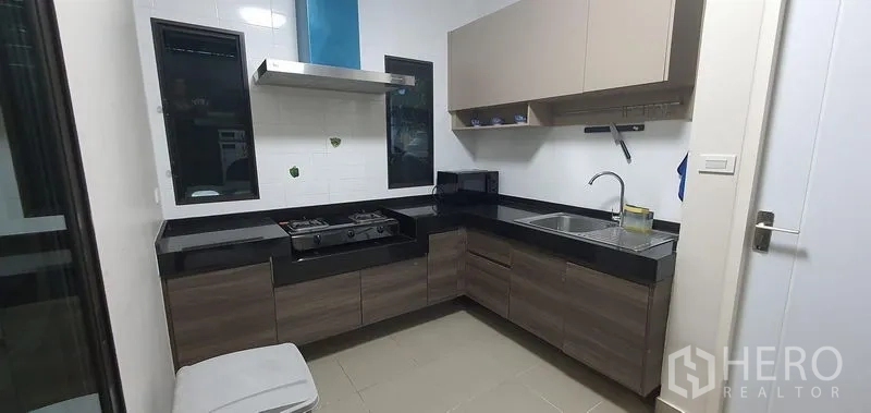 บ้าน ให้เช่าในBang Phli, Samut Prakan - ครัวรูปตัวแอล เคาน์เตอร์หินสีดำ เตาแก๊สและเครื่องดูดควัน