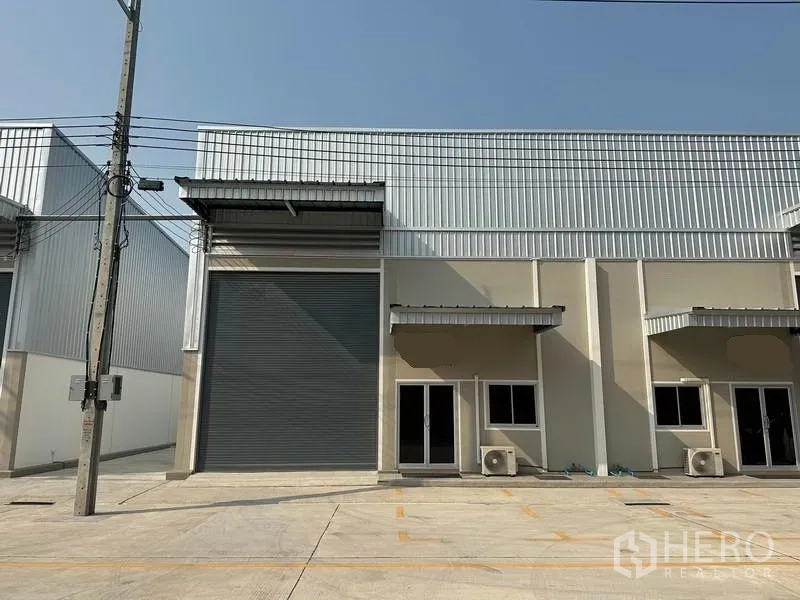 工厂 出租在Bang Phli, Samut Prakan - 单体工厂正立面，高卷帘门与玻璃办公入口