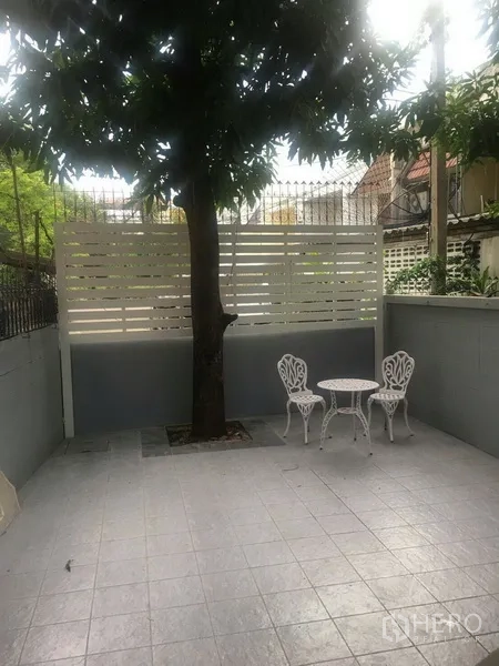 联排别墅 出租在Watthana, Bangkok - 私家庭院，有树、瓷砖地面和白色户外桌椅