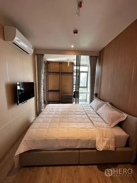 公寓 出租在Watthana, Bangkok - 现代卧室，壁挂电视、内置衣柜，落地窗通向城市景观阳台。