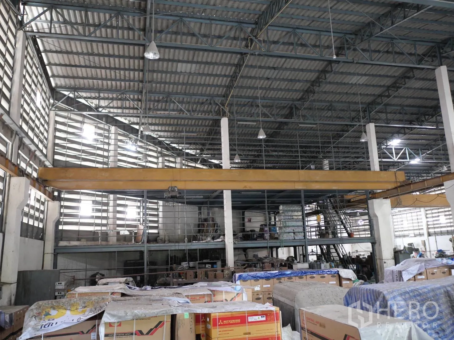 工厂 出租或出售在Bang Khun Thian, Bangkok - 仓库内部，黄色天车梁、夹层平台与楼梯。