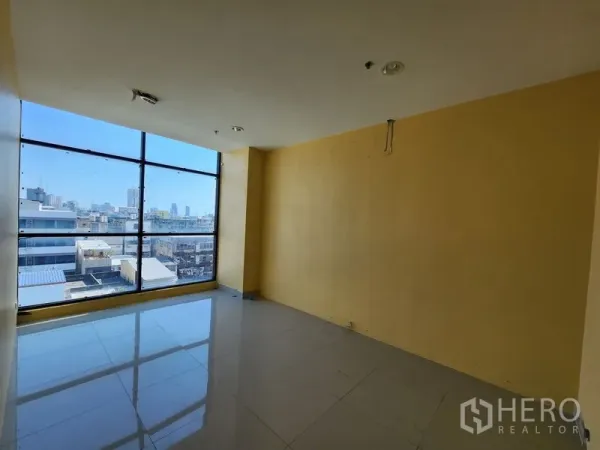 Retail Space for rent in Bang Rak, Bangkok - Sunlit retail unit with floor-to-ceiling window and Bangkok skyline view.