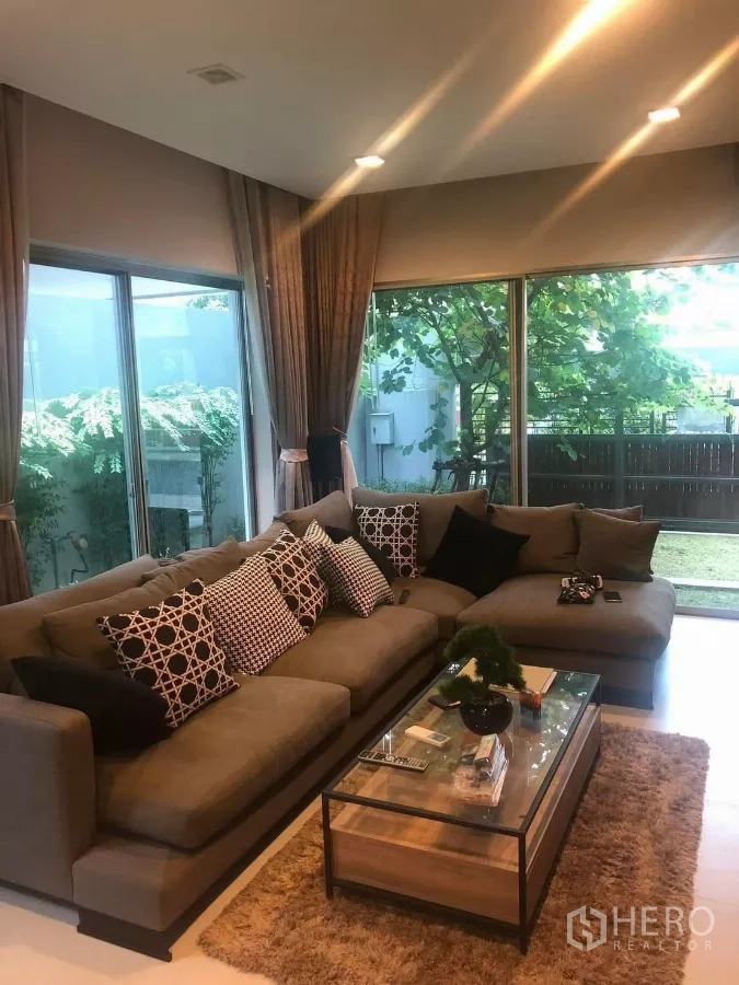 บ้าน ให้เช่าในBang Kapi, Bangkok - ห้องนั่งเล่นสว่างด้วยกระจกเต็มบาน โซฟาตัวใหญ่ มองเห็นสวน