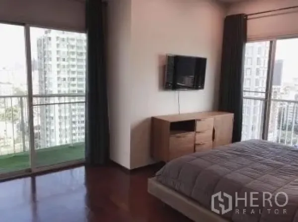 คอนโด ขายในWatthana, Bangkok - ห้องนอนใหญ่มีหน้าต่างมุมกว้าง ทางออกสู่ระเบียง และทีวีติดผนัง พื้นไม้
