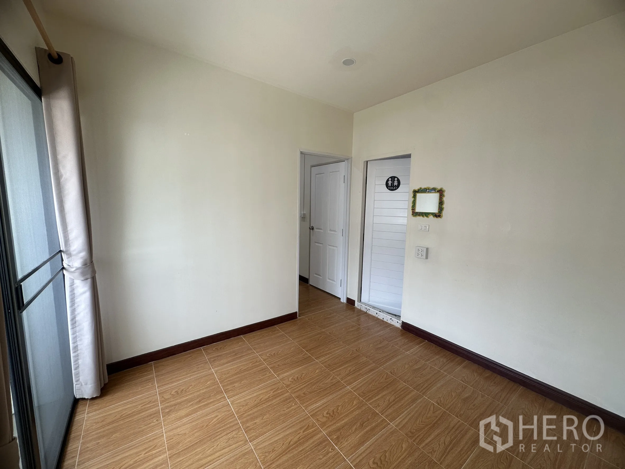 Townhouse for sale in Lam Luk Ka, Pathum Thani - Bedroom with sliding glass door and a nearby bathroom door.