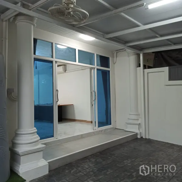 Townhouse for rent in Wang Thonglang, Bangkok - Covered carport with classic columns and glass entry to the house.