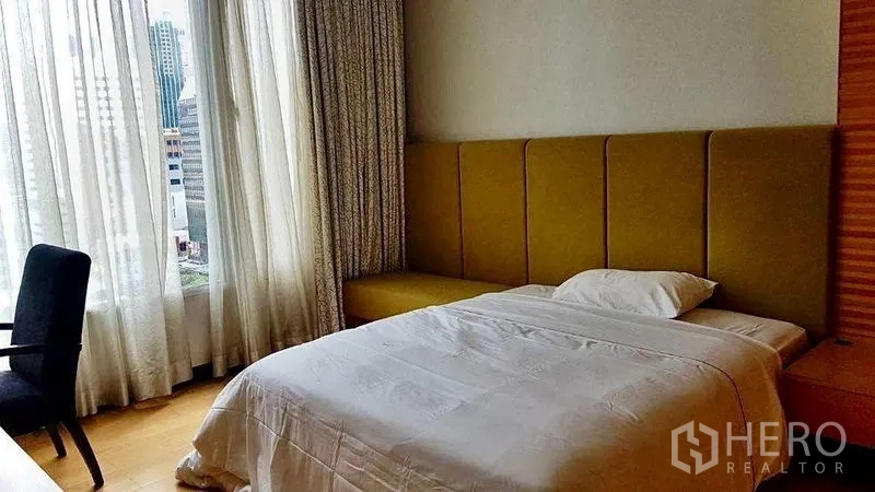 公寓 出租在Pathum Wan, Bangkok - 明亮卧室，软包床头与全高窗帘，欣赏曼谷城市景观。