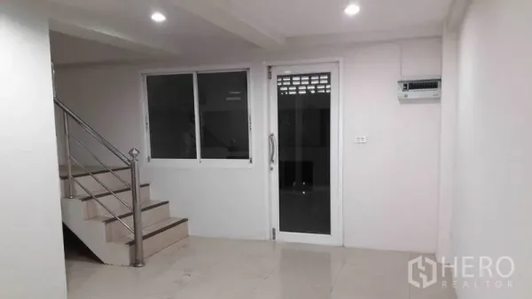 办公空间 出租在Bueng Kum, Bangkok - 明亮办公室内的不锈钢楼梯，旁有玻璃门与窗。