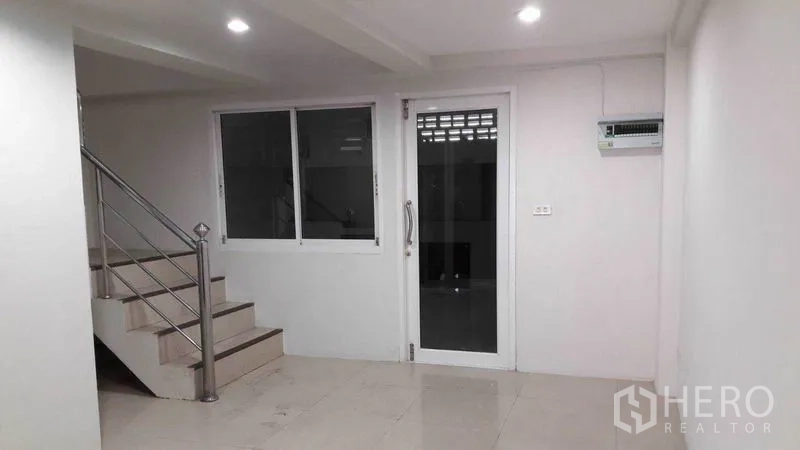 办公空间 出租在Bueng Kum, Bangkok - 明亮办公室内的不锈钢楼梯，旁有玻璃门与窗。