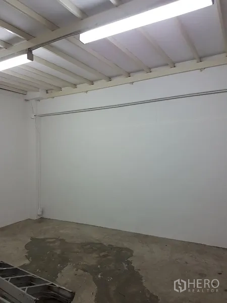 Home Office for sale in Khlong Toei, Bangkok - Empty white room with exposed ceiling beams and concrete floor.