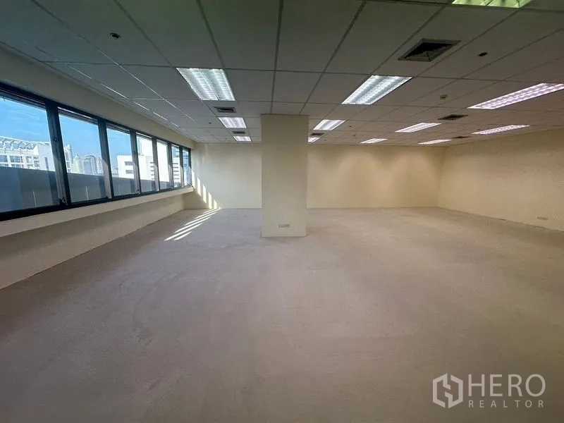 Office Space for rent in Bang Na, Bangkok - Bright office corner showing a central pillar and panoramic windows overlooking Bangkok.