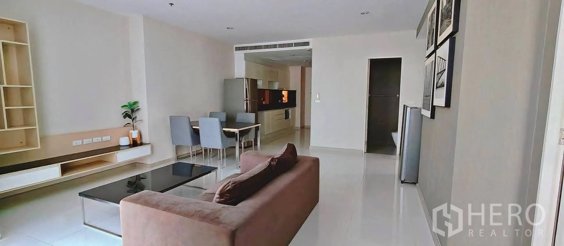 公寓 for rent in Watthana, Bangkok - 开放式客厅设有沙发、玻璃茶几、四人餐桌和内置电视柜。