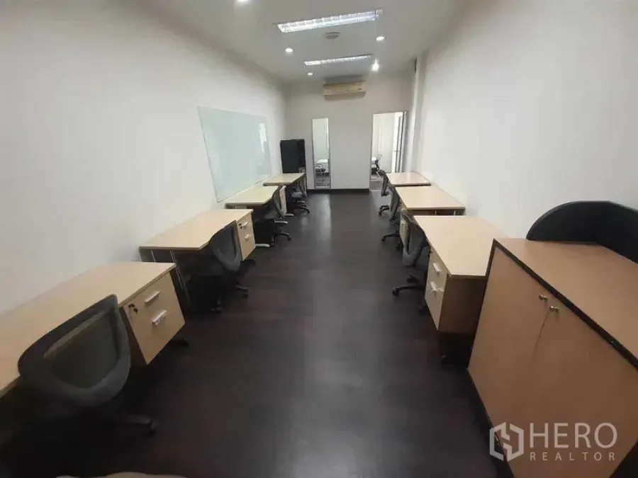 办公空间 出租在Khlong Toei, Bangkok - 配有多张工位和椅子的办公室，白板、深色木地板、筒灯与空调