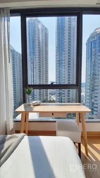 公寓 出租在Khlong Toei, Bangkok - 卧室角落书桌靠大窗，欣赏高楼城市景观。