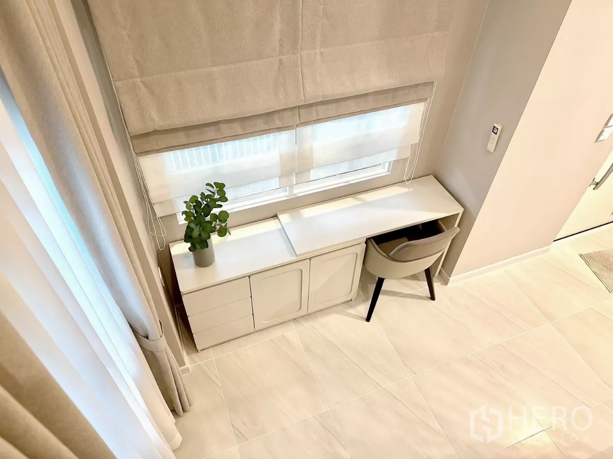 Detached House for rent in Bang Phli, Samut Prakan - Top view of a window-side work desk with cabinet storage and a small indoor plant.