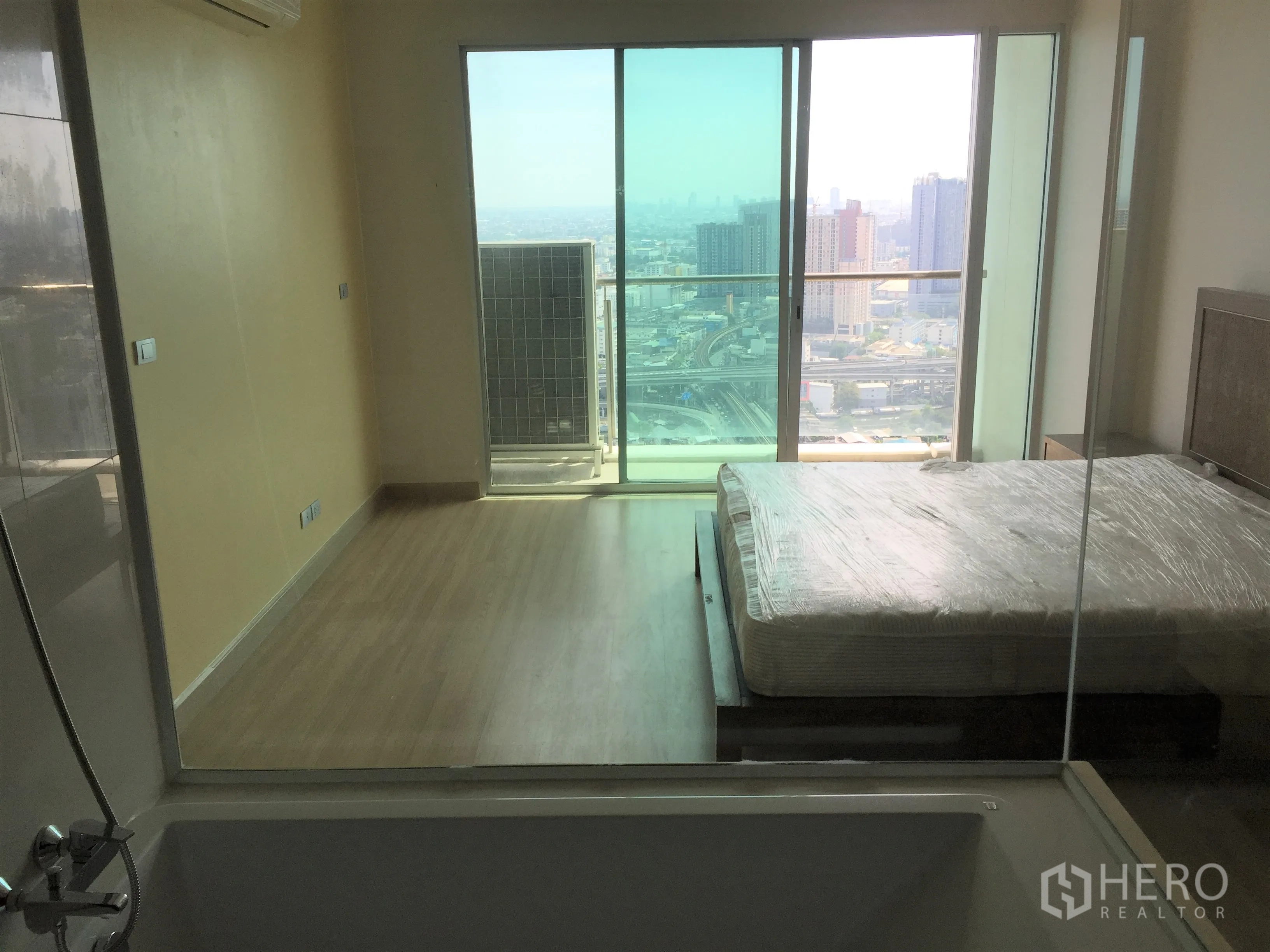 คอนโด ขายในWatthana, Bangkok - ห้องนอนมาสเตอร์พร้อมระเบียงวิวเมือง และผนังกระจกเชื่อมห้องน้ำ