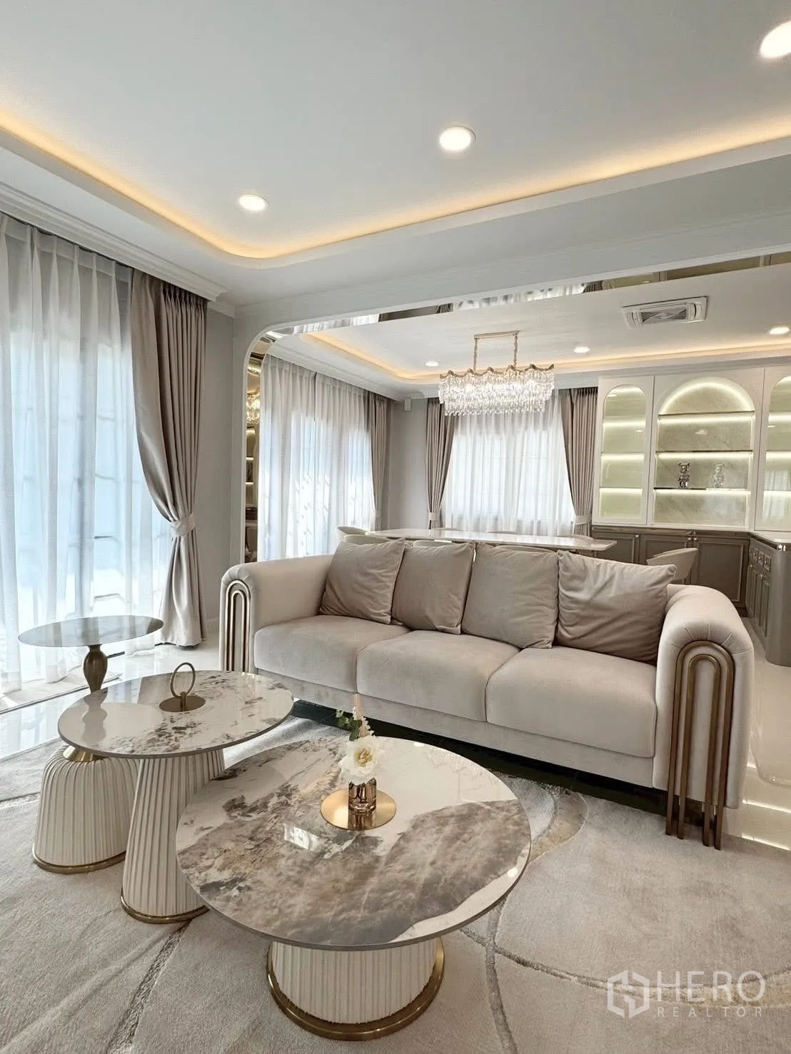 独立式住宅 出租在Bang Phli, Samut Prakan - 雅致客厅，米色沙发与大理石茶几，氛围灯带。