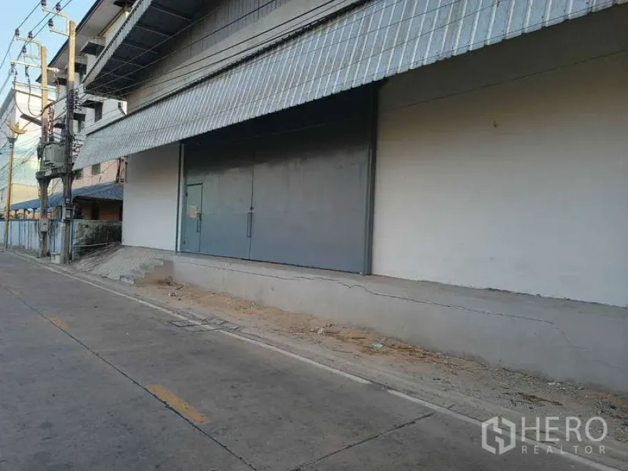 Warehouse for rent in Bang Phli, Samut Prakan - Front elevation of the warehouse showing metal awning and raised loading platform.